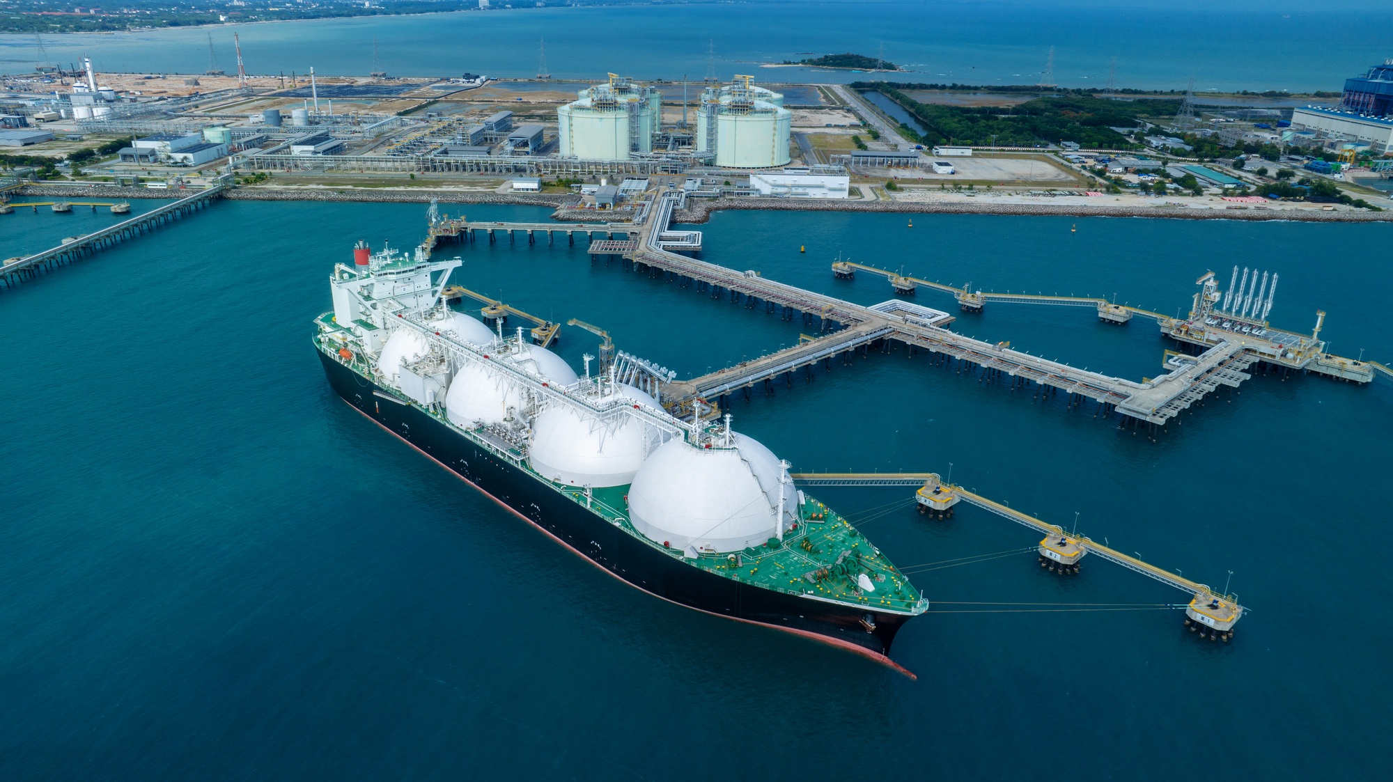 LNG (Liquified Natural Gas) tanker anchored in Gas terminal gas tanks for storage.